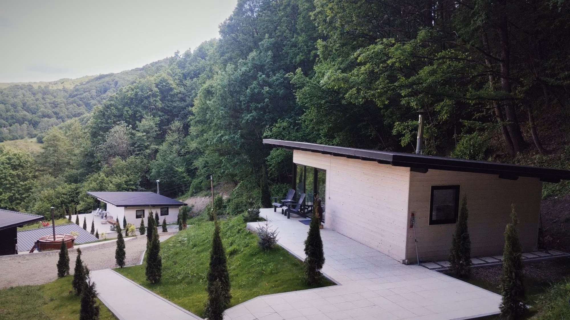 Cele două cabane așezate sub versantul împădurit al Văii Ursului